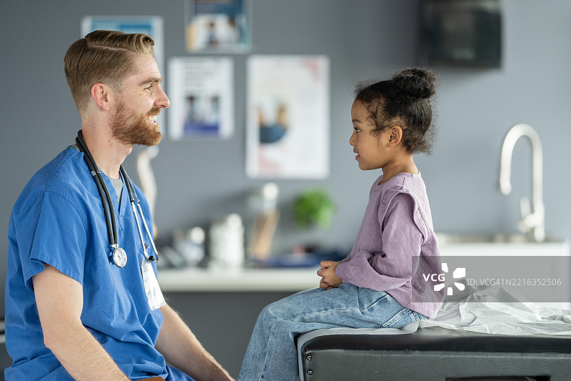 医生在医院与儿童患者进行医疗检查互动图片素材
