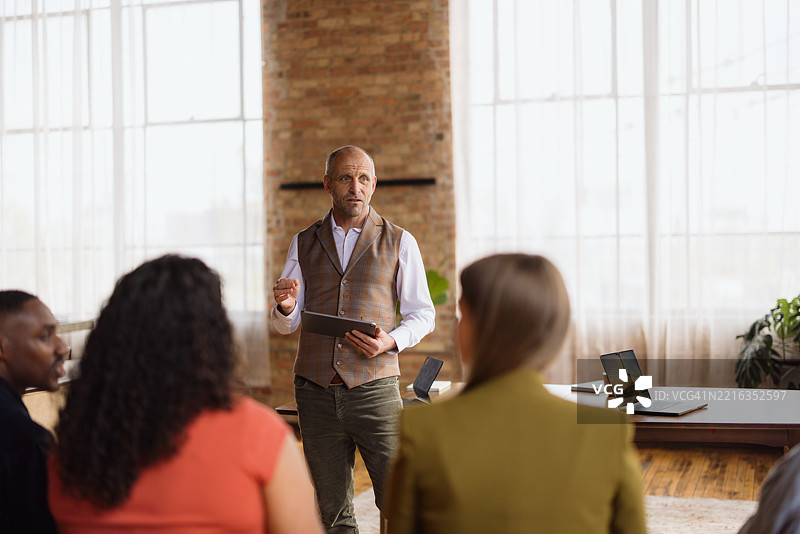 成熟的商人正在用平板电脑带领团队会议图片素材