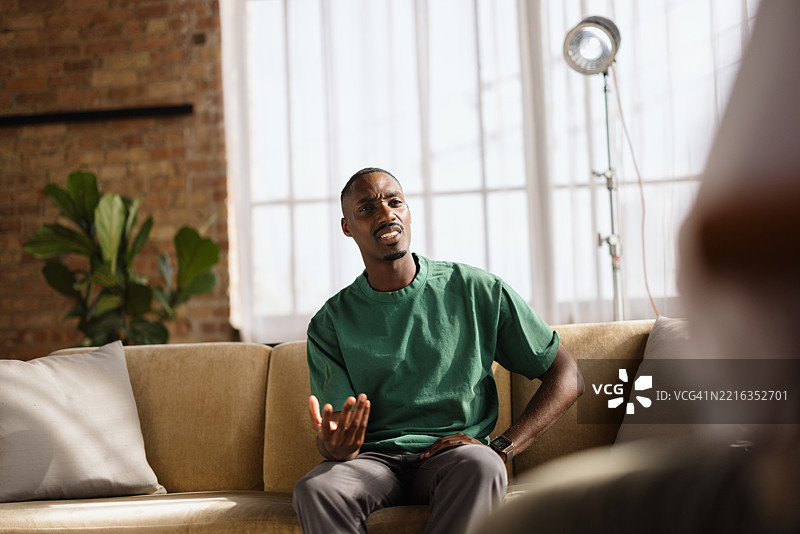 年轻男子在治疗会议中与心理医生交谈图片素材