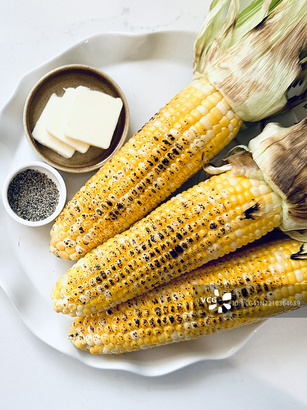 黄油和黑胡椒调料的烤玉米拼盘图片素材