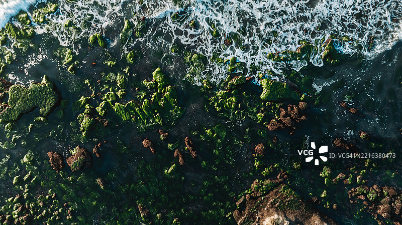 海浪拍打海岸岩石和珊瑚礁的鸟瞰图图片素材