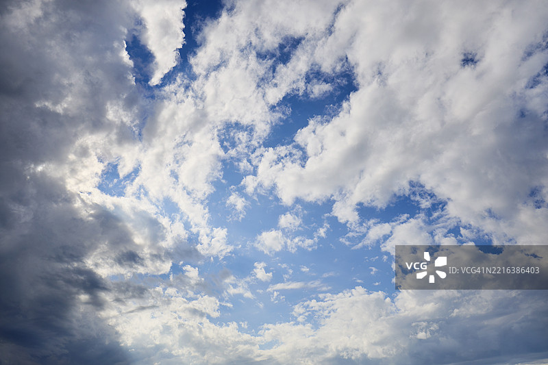 全景拍摄的戏剧性天空，黑云与蓝天交织在一起图片素材