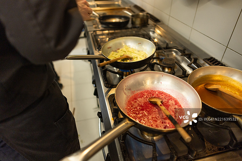 年轻厨师在餐厅厨房准备意大利面图片素材