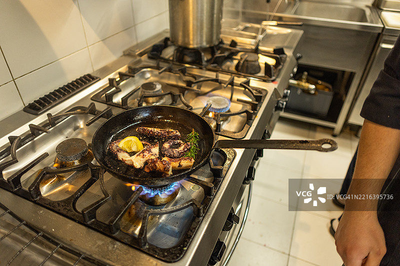 年轻厨师在餐厅厨房准备意大利面图片素材