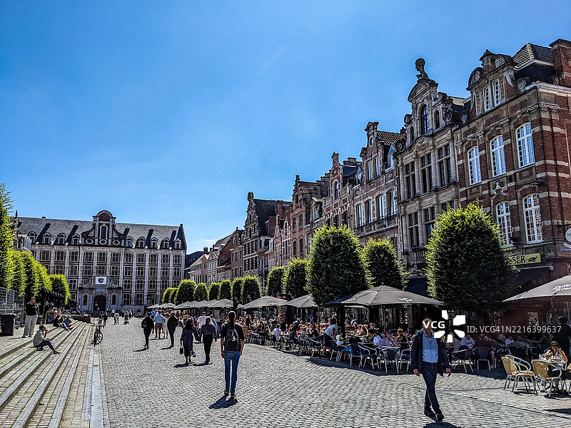 人们在鲁汶老市场广场的人行道咖啡馆中享受时光图片素材