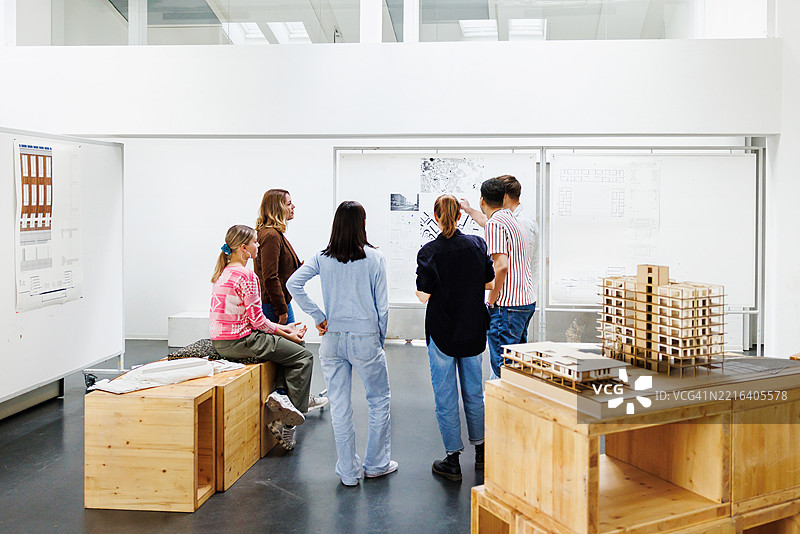 建筑学生在明亮的大学教室中审查城市规划图片素材