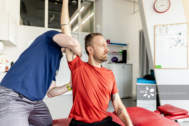 男性患者在诊所接受专业物理治疗师的手臂治疗图片素材