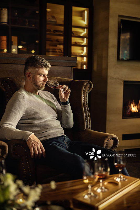 成年男子在时尚酒吧享受朗姆酒、干邑或威士忌图片素材