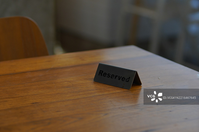 咖啡店背景中深棕色木桌上的预留标志图片素材