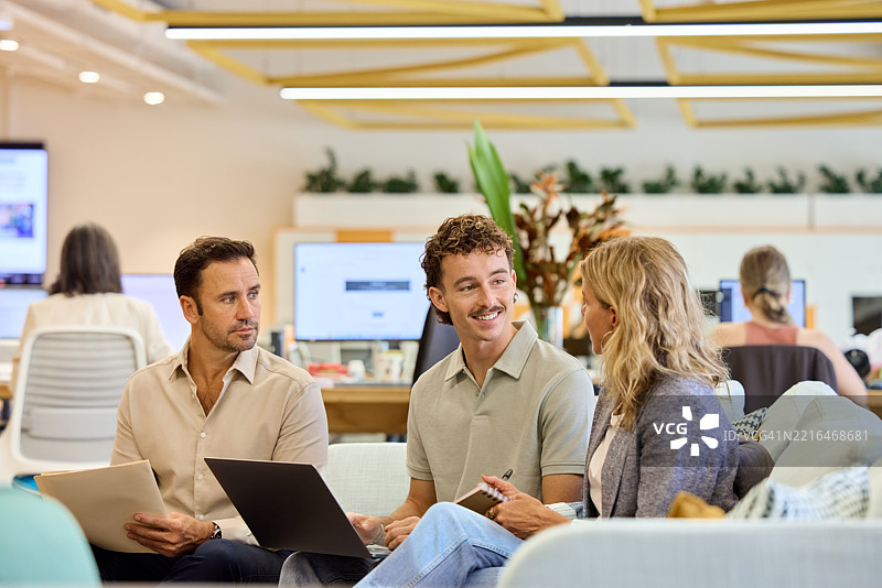 微笑的男性员工在倾听经理的讲话图片素材