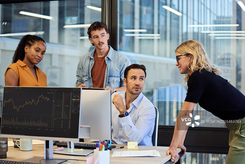 经理倾听靠在桌子上的女性同事图片素材