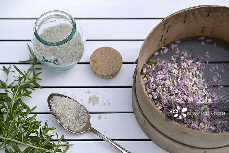 户外桌子上摆放着香草、海盐和细香葱花图片素材
