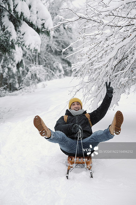 成熟男性在冬季雪林中享受有趣的滑雪之旅图片素材