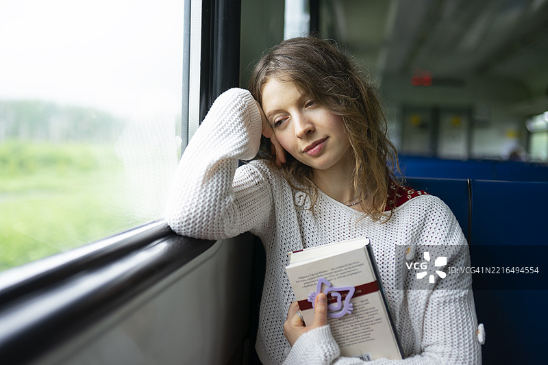 女孩在火车上阅读一本书，独自一人，中年女性，白人图片素材