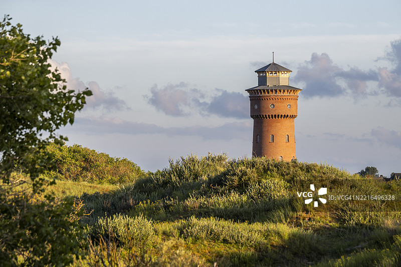 德国下萨克森州博尔库姆岛上的历史水塔，四周环绕着自然景观图片素材