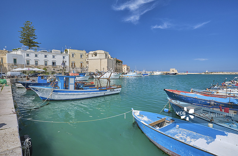 意大利阿普利亚的特拉尼风景如画的港口停靠着船只，阳光明媚。图片素材