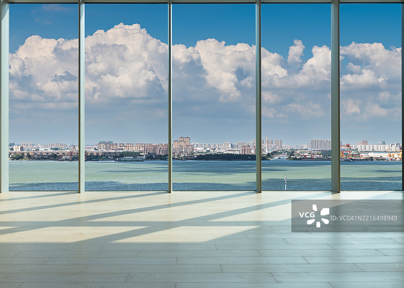 透过玻璃窗，在屋顶上俯瞰长江对岸的城市图片素材