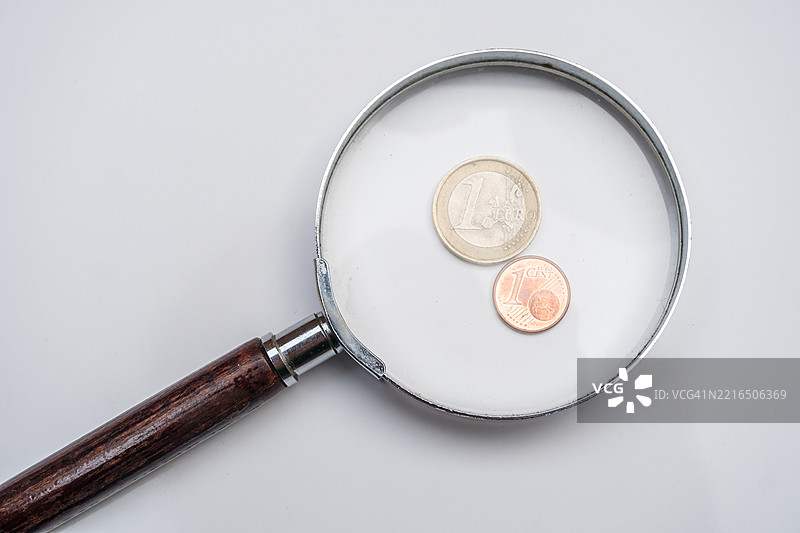 放大镜下的一欧元和一分硬币特写图片素材
