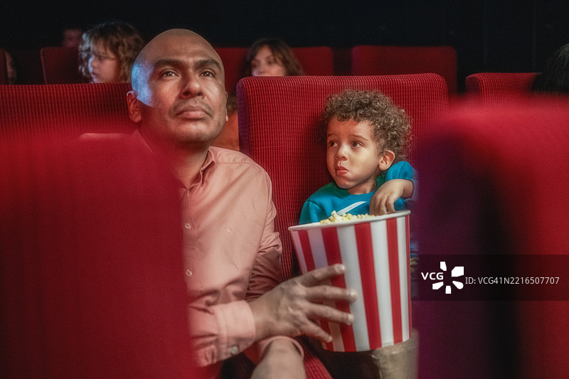 父亲和儿子在电影院享受电影时光图片素材