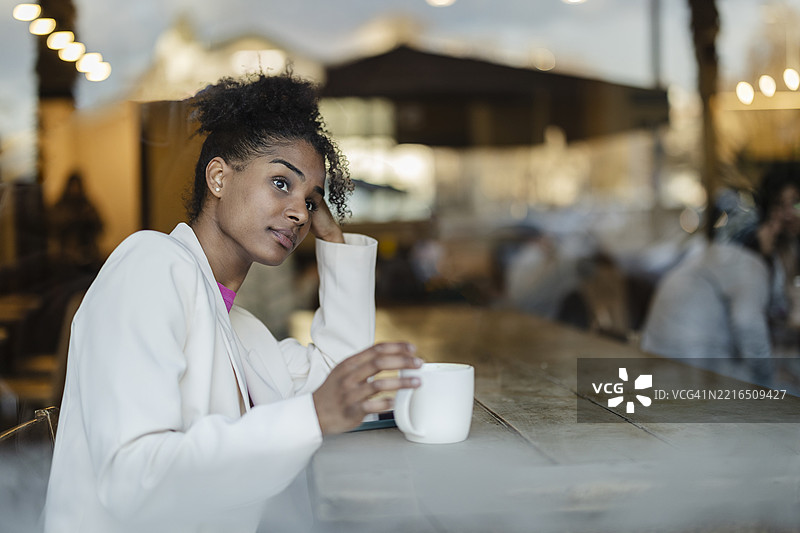 女性在舒适的城市咖啡馆享受咖啡图片素材