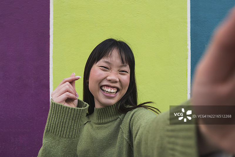 快乐的女人在色彩斑斓的街道上自拍图片素材