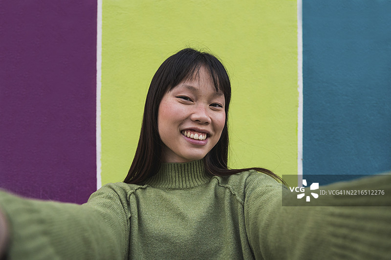 女人在色彩斑斓的街道上自拍图片素材