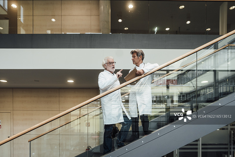 医生们在医院楼梯上讨论并拿着文件图片素材