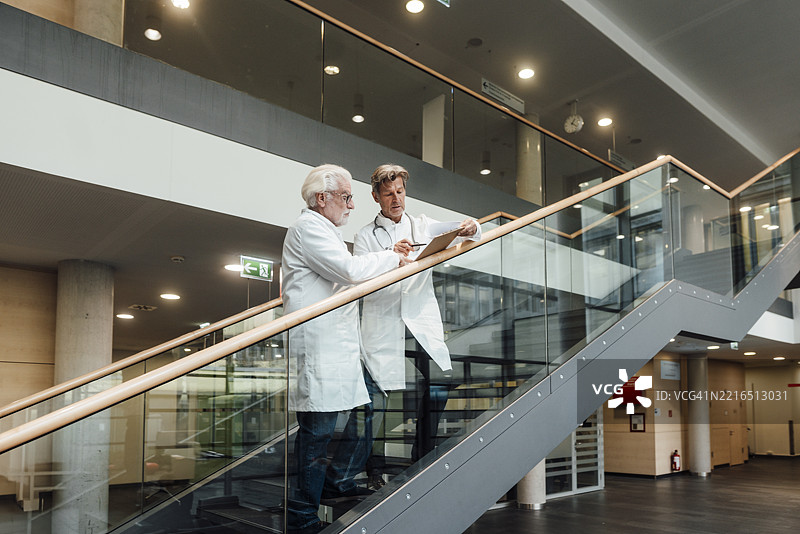 医生们在医院楼梯上讨论并拿着文件图片素材