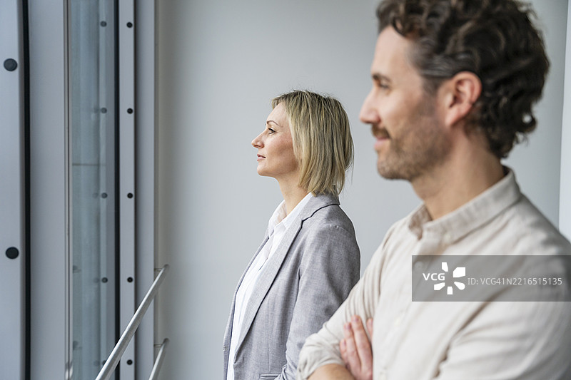 商务专业人士在现代办公室里望向窗外图片素材