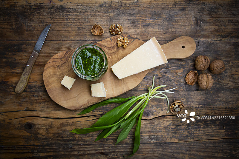 野蒜香蒜酱配帕尔马干酪和核桃，摆放在质朴的木桌上图片素材