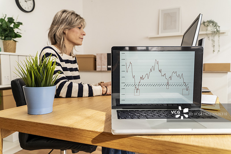 女商人在办公室工作区使用笔记本电脑分析数据图片素材