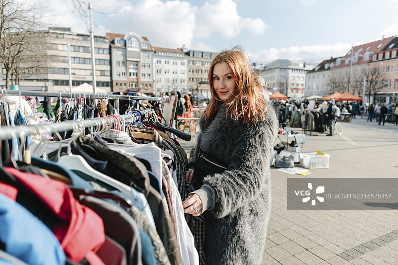 在德国卡尔斯鲁厄的跳蚤市场购物的红发女性图片素材