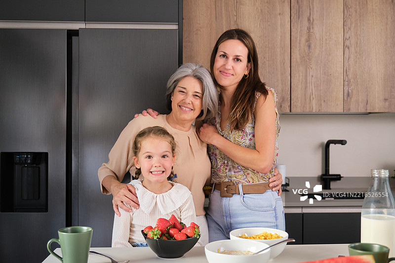 快乐的三代同堂家庭在厨房享用早餐时微笑图片素材