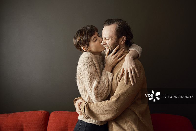 情侣在温馨的房间里相拥亲吻图片素材