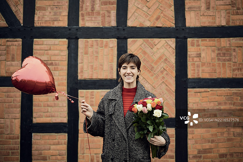 伦敦街头的女人手捧鲜花和心形气球图片素材