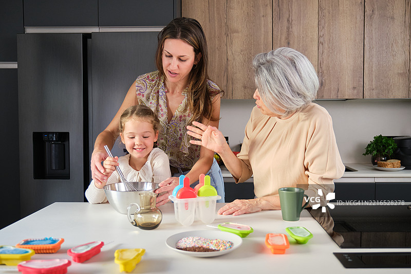 三代同堂的家庭在现代厨房一起制作冰淇淋图片素材