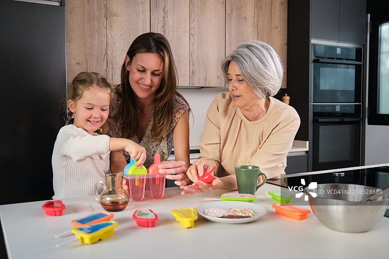 三代同堂的家庭在现代厨房一起制作冰淇淋图片素材