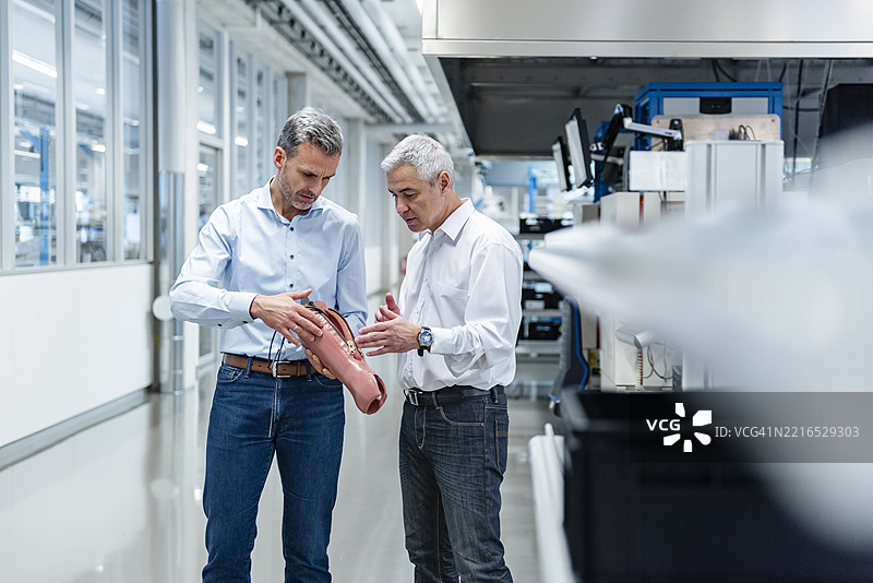 两位专业人士在生产大厅讨论假肢图片素材