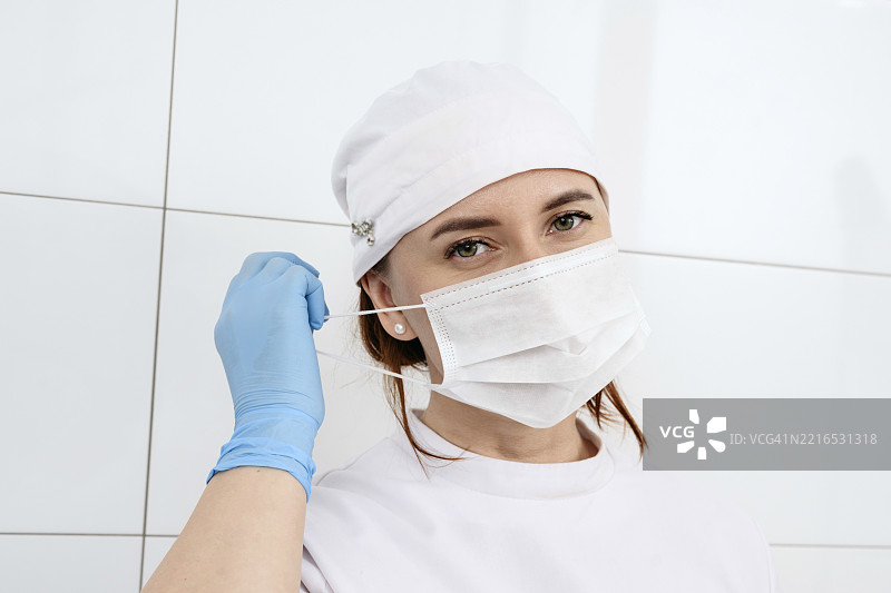 在医疗环境中戴着外科口罩和手套的医生肖像图片素材