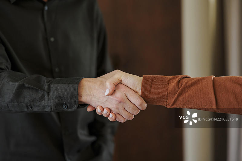 室内两位商务专业人士握手的特写镜头图片素材