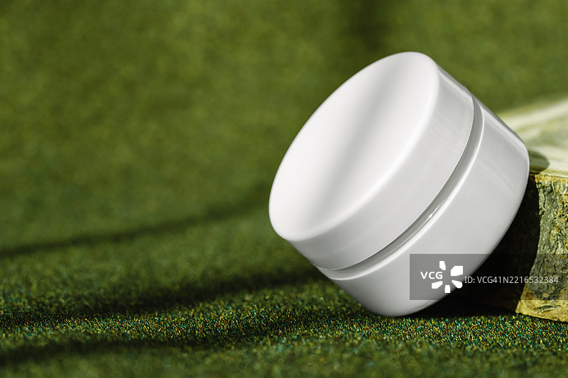 放在圆形木质展示台上的紧致霜瓶，含有胶原蛋白图片素材