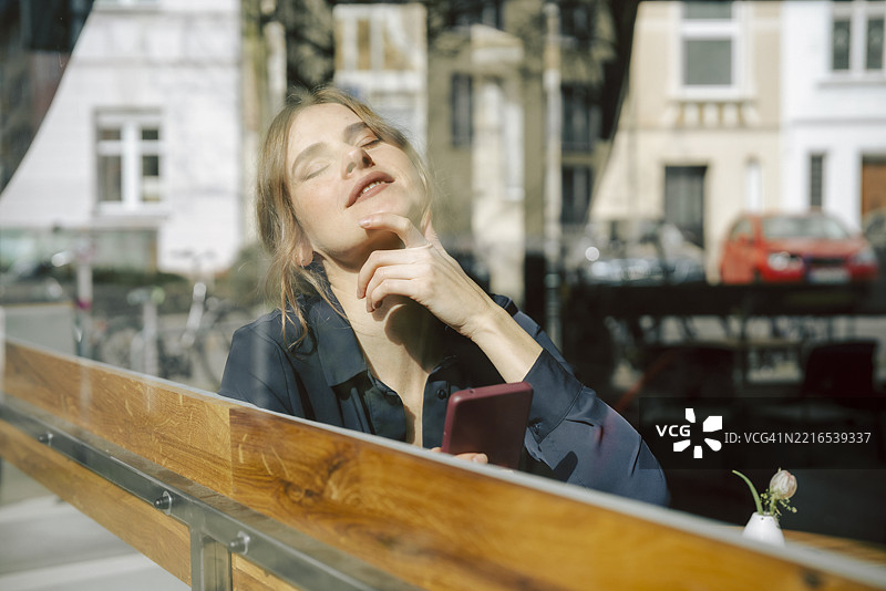 女人在咖啡馆里用智能手机享受放松时光图片素材