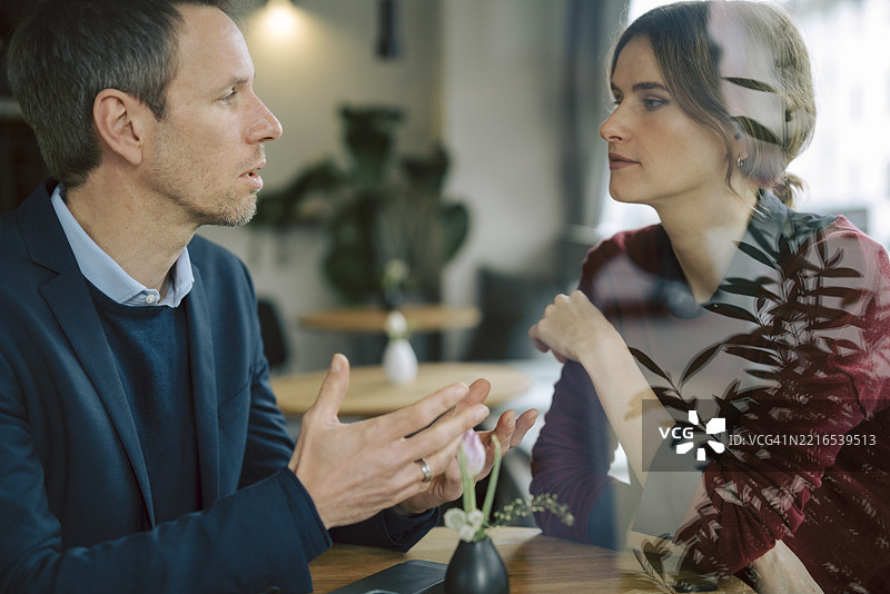 在咖啡馆环境中进行的商务讨论，重点关注沟通与团队合作图片素材