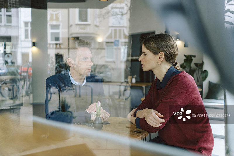 在咖啡馆环境中进行的商业讨论，重点关注沟通与团队合作图片素材