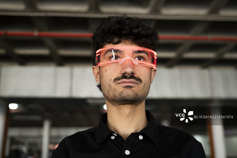 戴着虚拟现实眼镜的男子在室内仰望，风格未来感十足图片素材