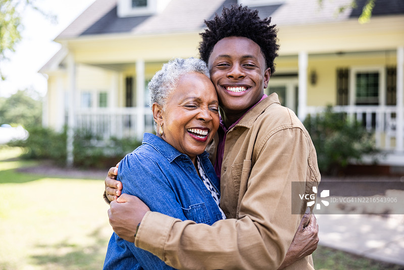 乡村农舍前的老年女性与孙子的肖像图片素材