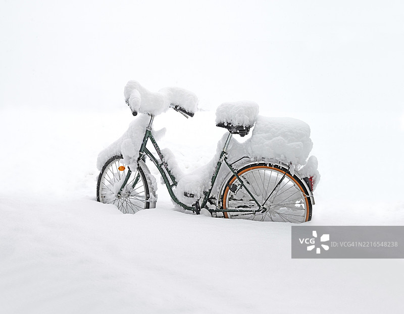 覆盖着雪的巡洋舰风格自行车停在深雪中，地点：德国下巴伐利亚州普拉特林，欧洲，12月图片素材