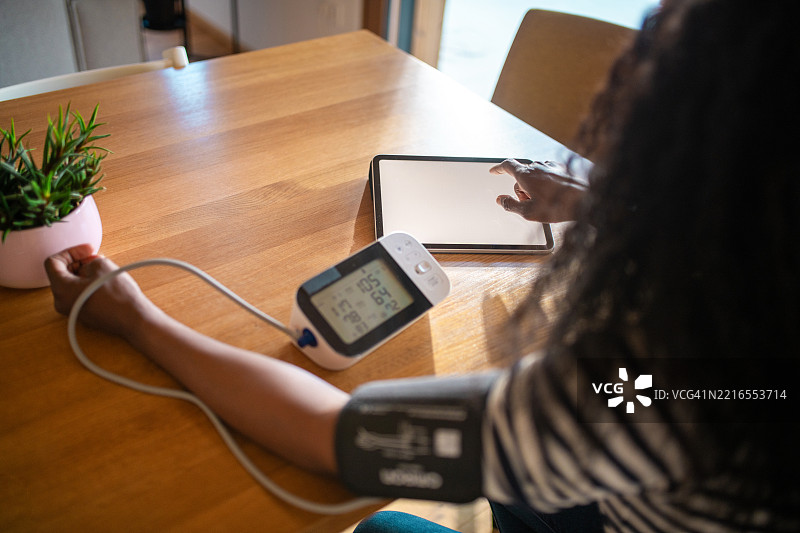 中年黑人女性在木桌上自测血压图片素材