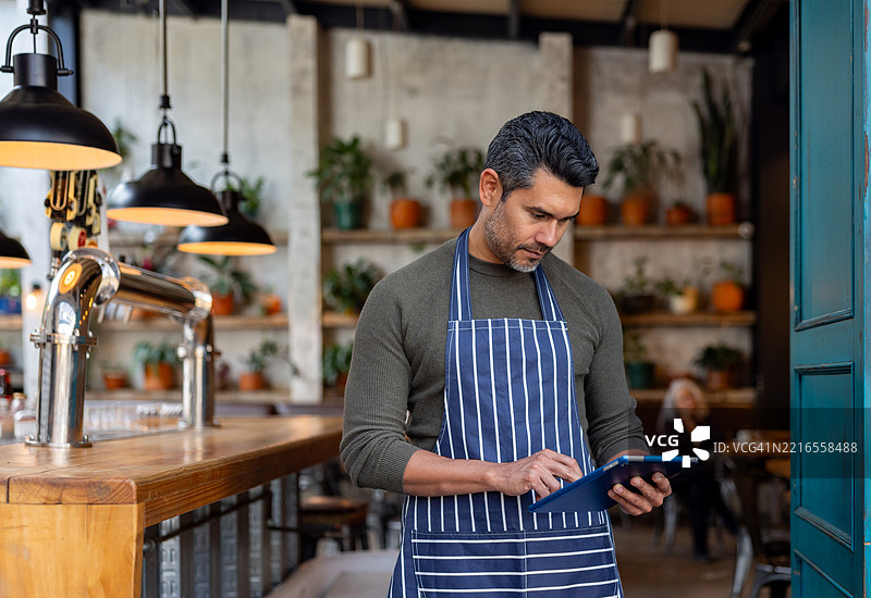 在餐厅工作的服务员使用数字平板电脑图片素材