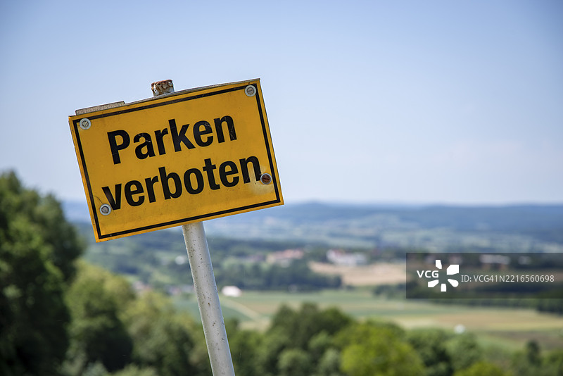 禁止停车的黄色标志，前方是丘陵的绿色风景，德国，欧洲图片素材